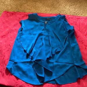 Sleeveless blouse with rounded neck and slit front and metal clasp